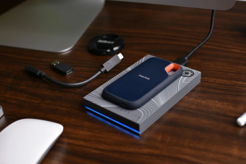 a device on a wooden surface beside a usb cable