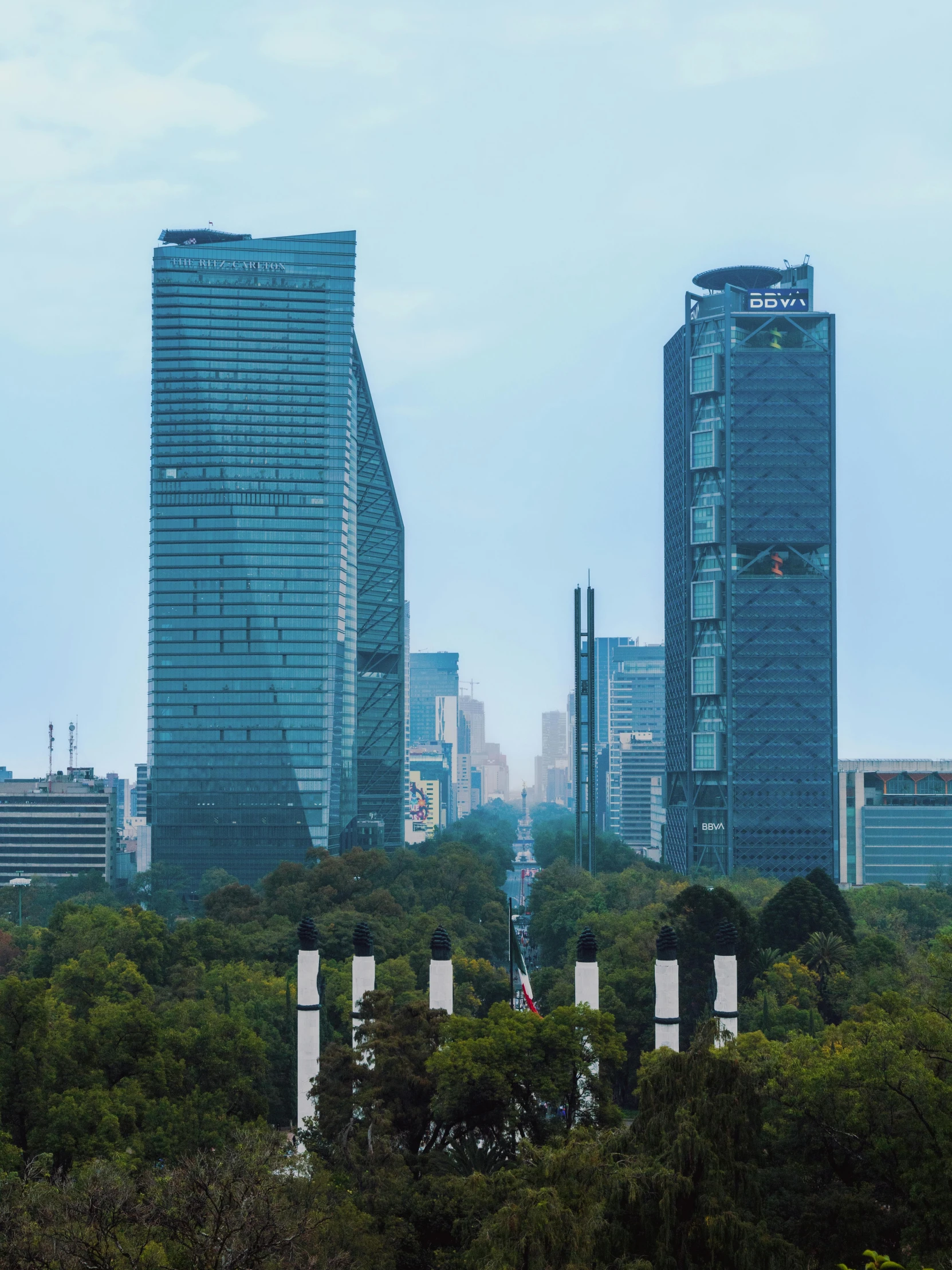 a view of tall skyscrs with trees around them