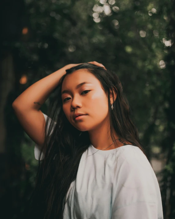 an asian woman is standing alone in the park