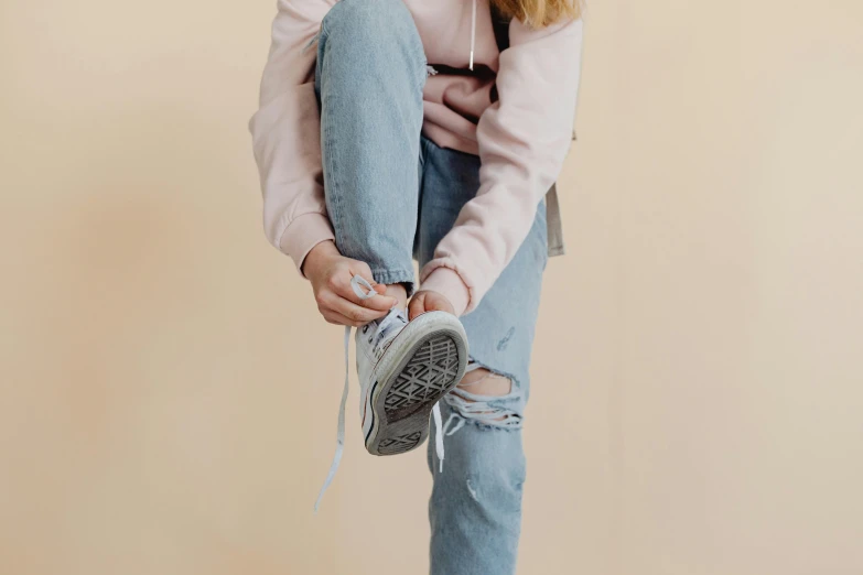 a little girl is sitting on top of someones jeans