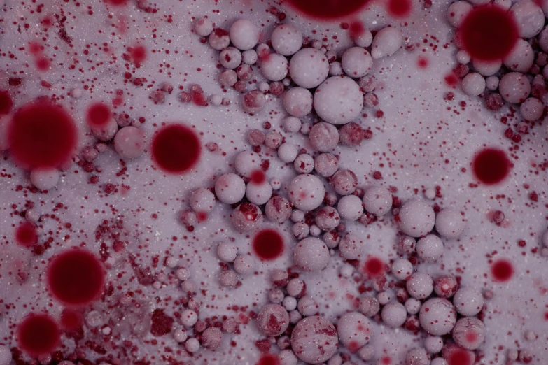 , white and red bubbles on a black surface