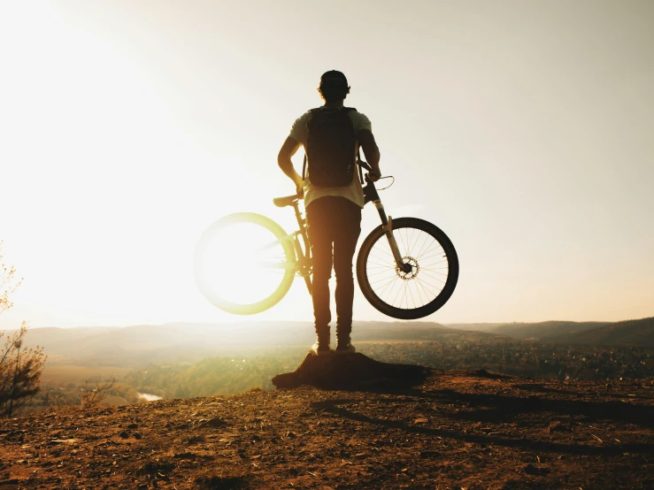 the man is holding two giant bikes in his hands