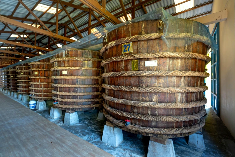 a group of wooden barrels are lined up against the wall