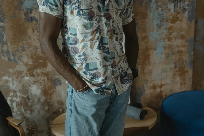 a man in a white shirt is standing near a chair