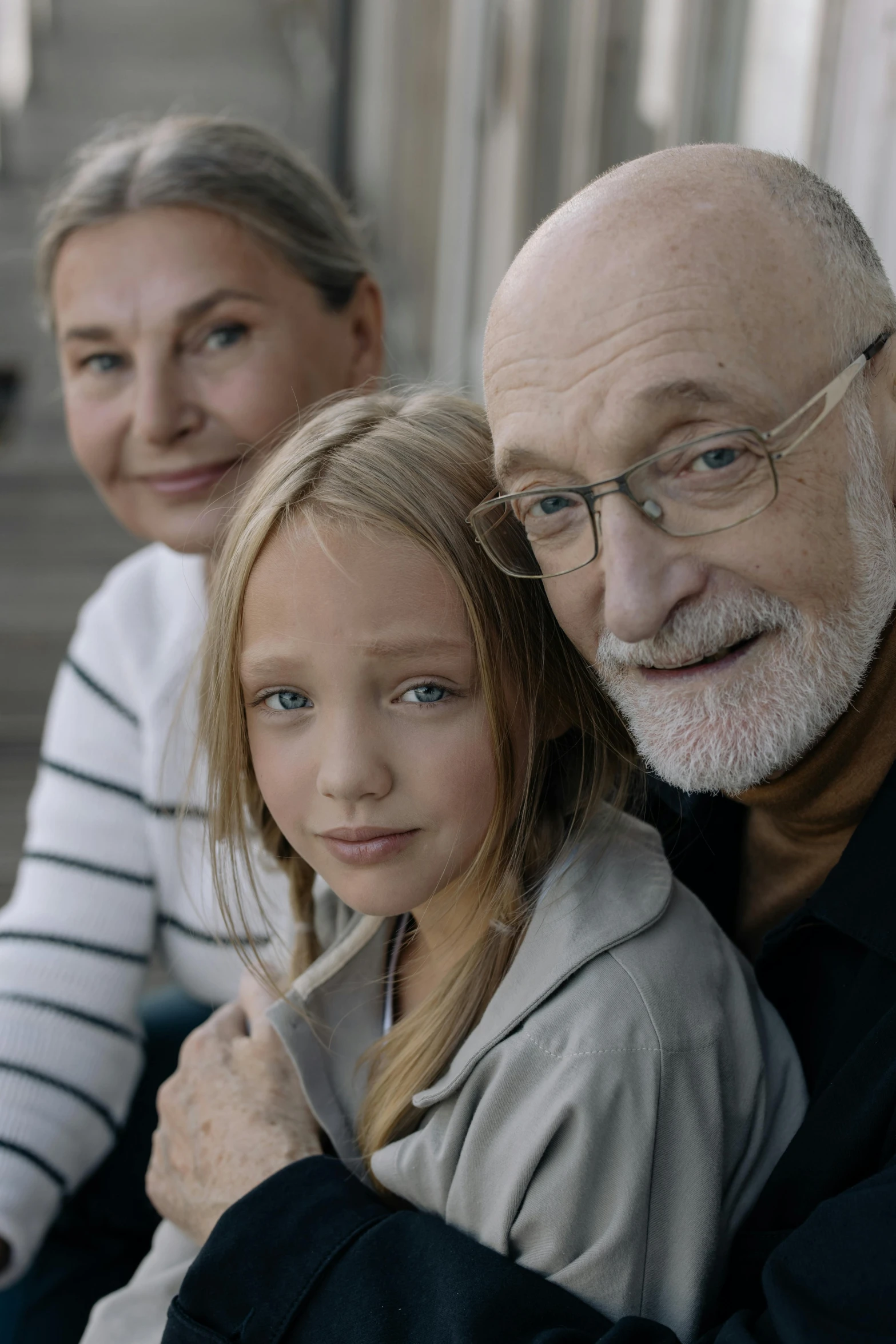 an older man, a woman and a child are posing for a po