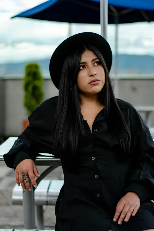 a woman in a black shirt sitting on a bench