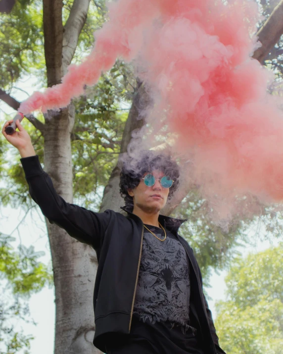 a person holding out a pink smoke bomb