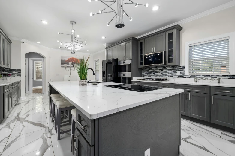 an elegant kitchen with marble countertops and gray cupboards