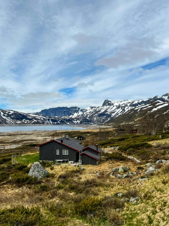 a black and grey house on a grass plain