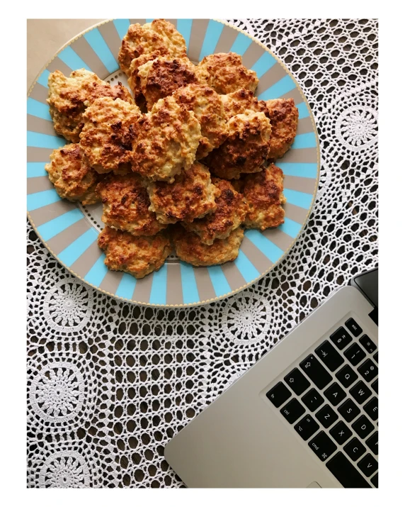 chicken balls on a plate with a laptop on the table