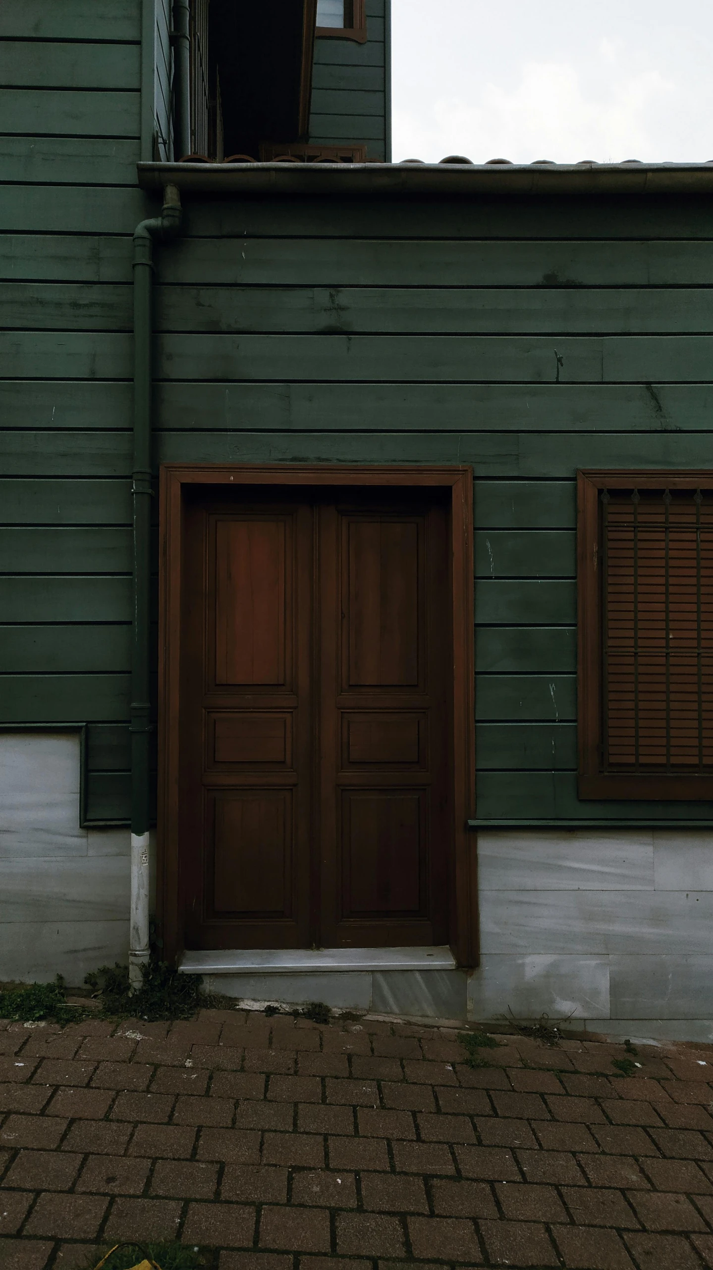 a couple of wooden doors are outside a building