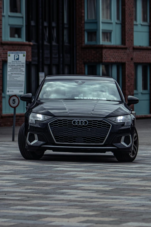 an audi is sitting in a parking lot with buildings