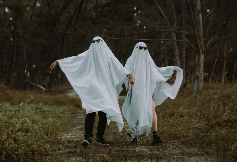 two white women dressed in ghost costumes and black boots
