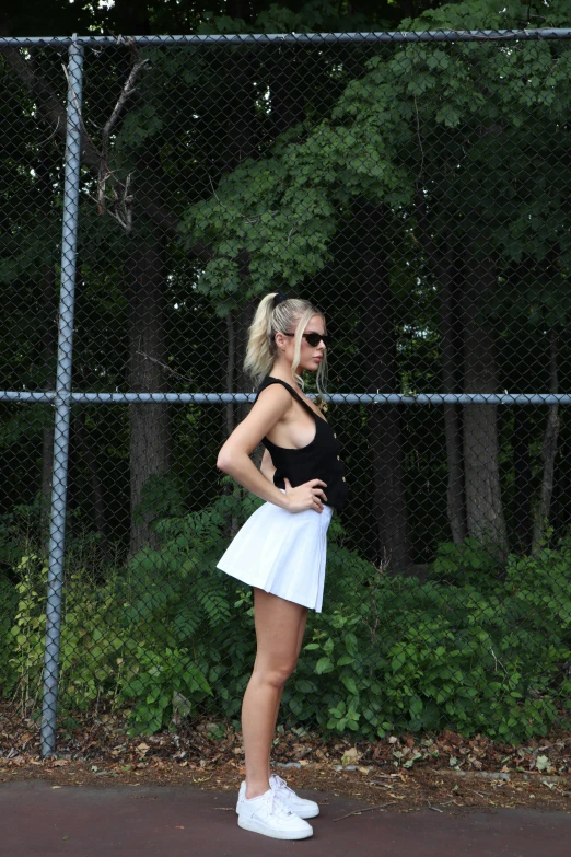 a young lady in tennis gear standing with her racket ready to play