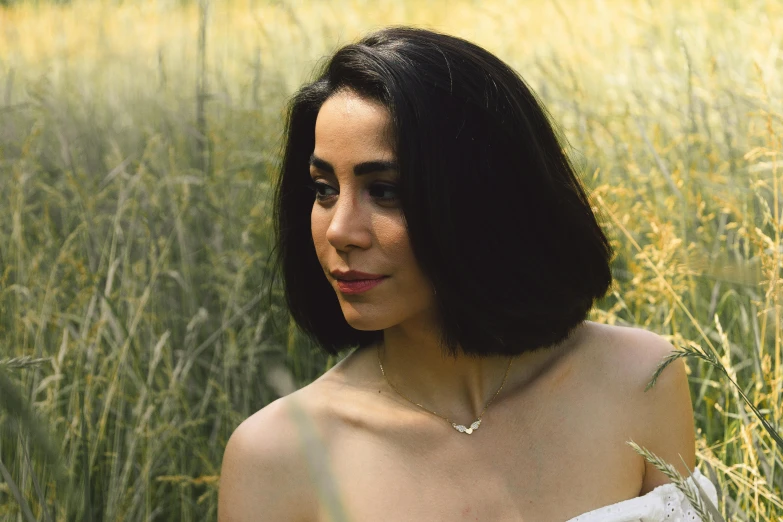 a beautiful young lady sitting in a field