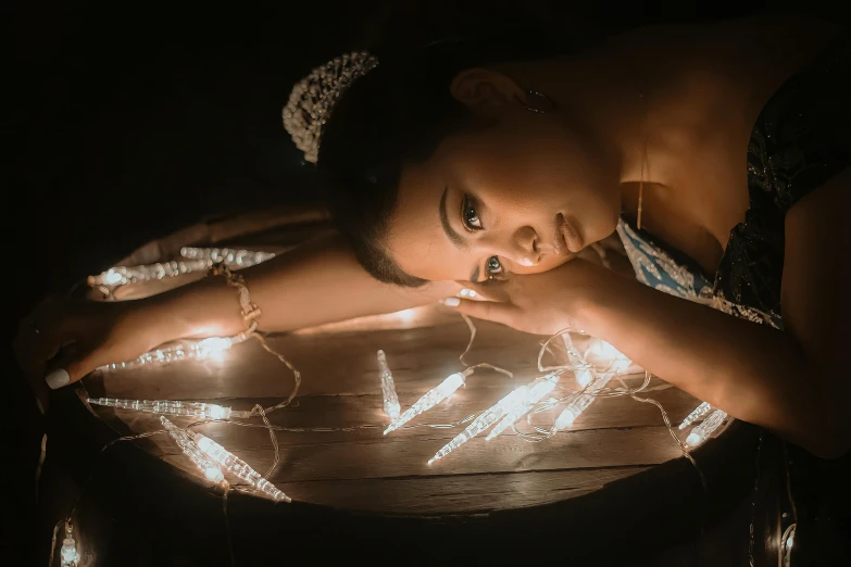 an image of a girl sitting down with some light decorations