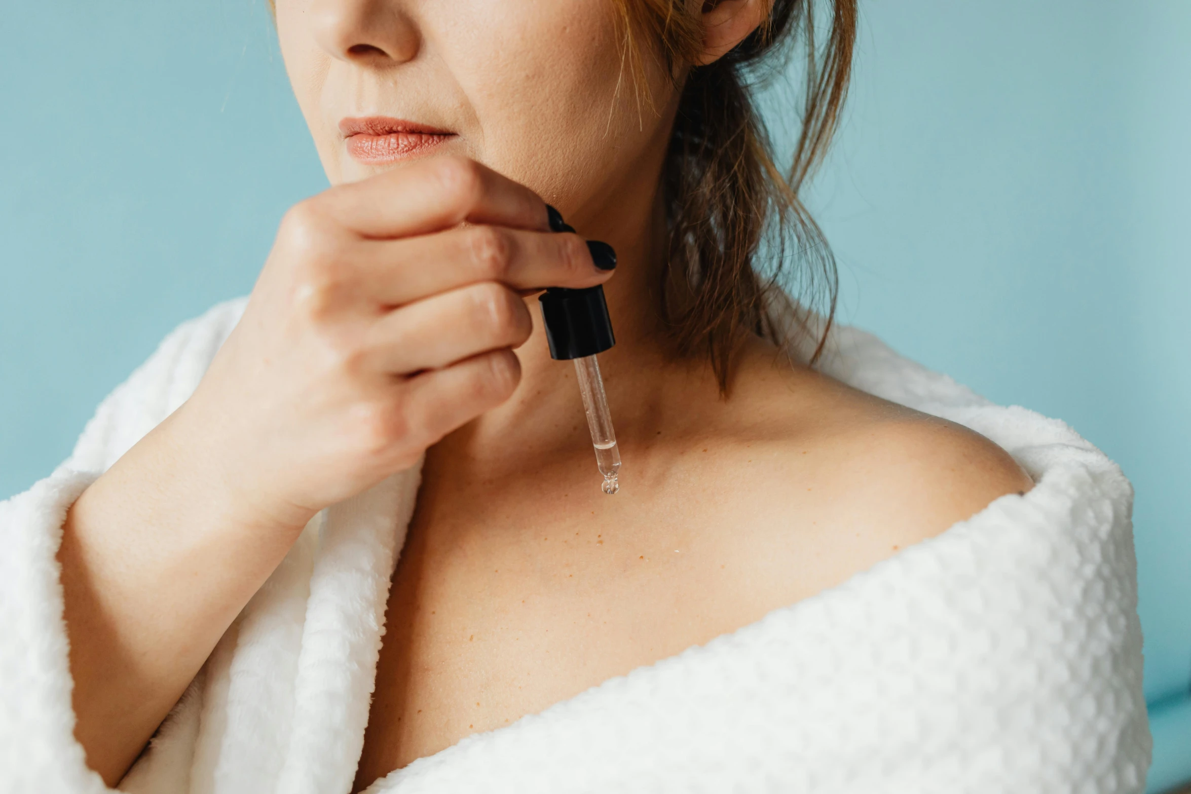 the woman wearing a white towel is holding an object