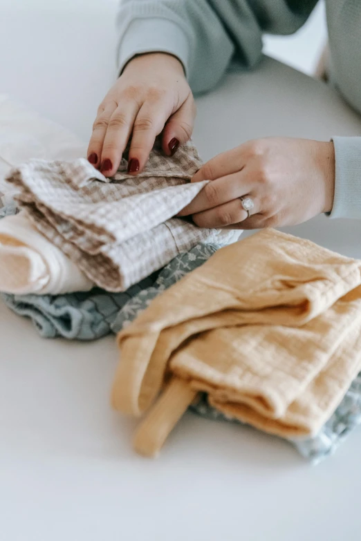 a woman that is standing up with a pile of clothes