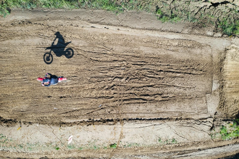 an aerial view of a dirt bike rider on a muddy road