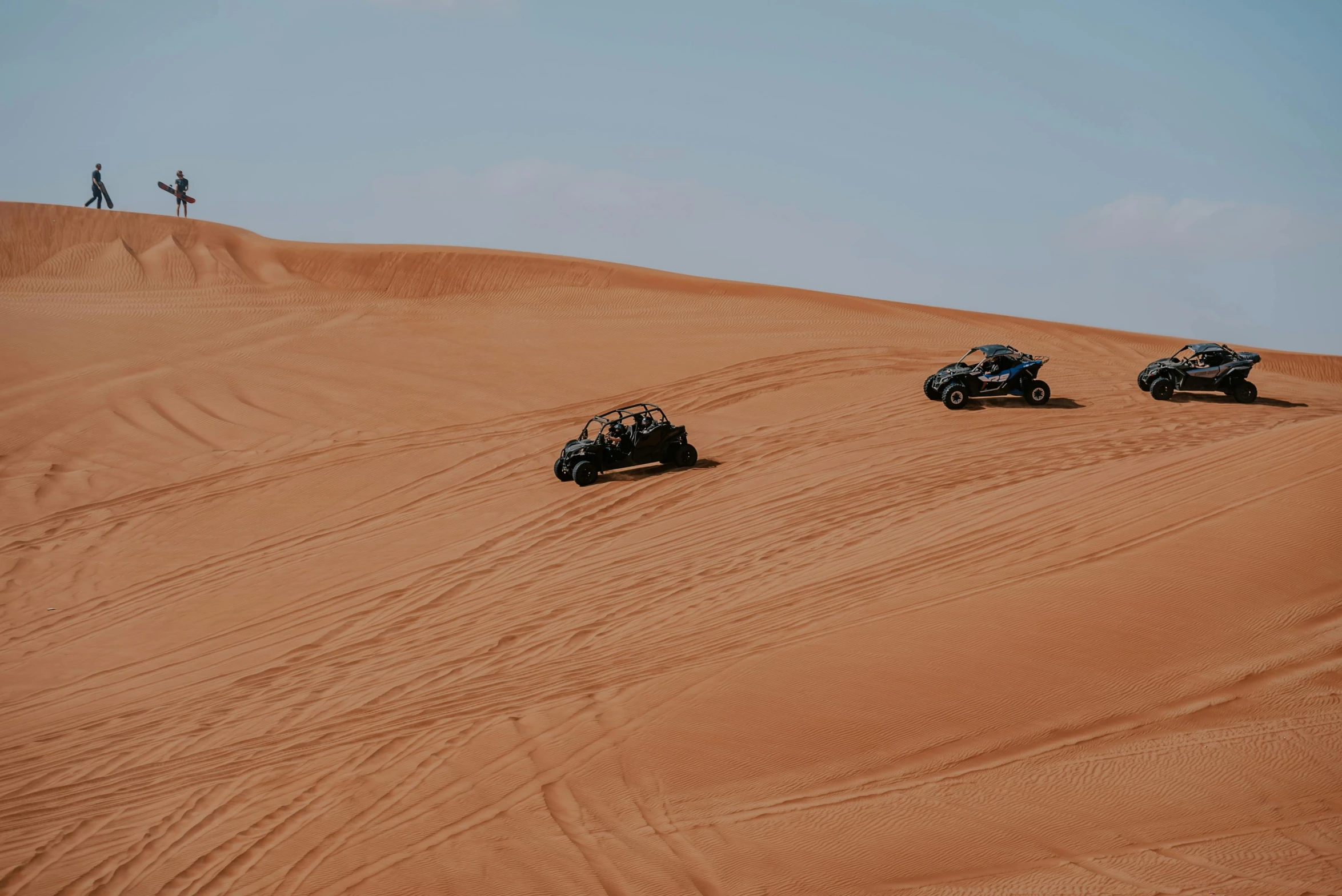 four atvs racing through a sandy area