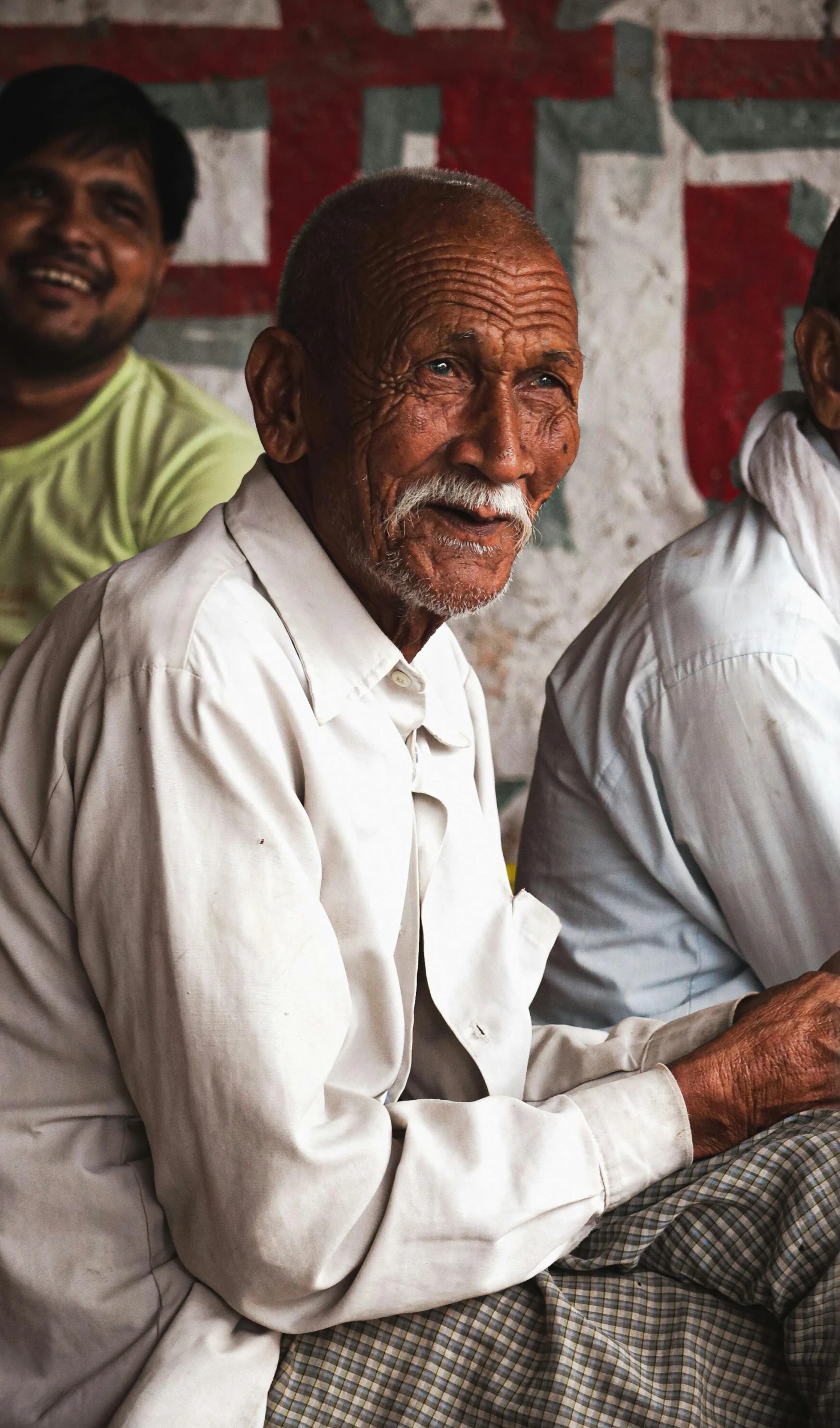 two elderly men are sitting side by side