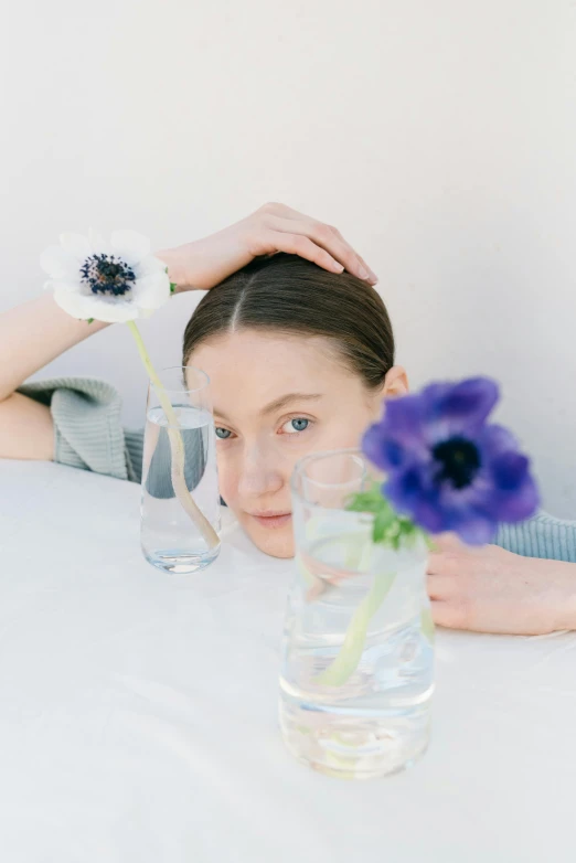 a girl putting water in a vase and flowers