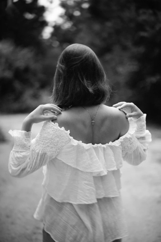 a woman in white blouse standing outdoors in a field