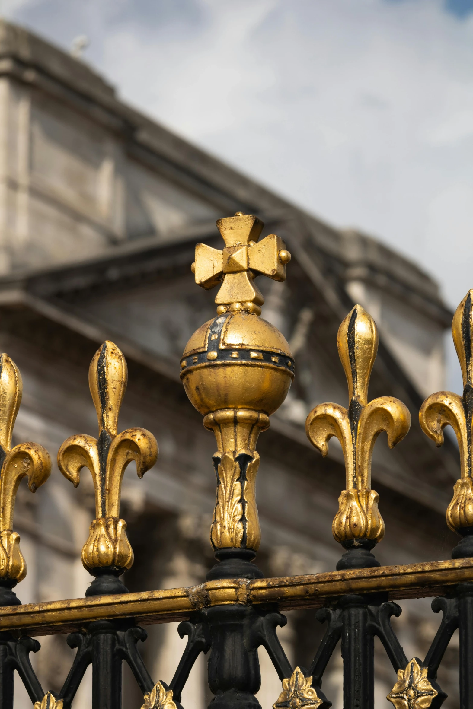 the large building has elaborate gold decorative fencing