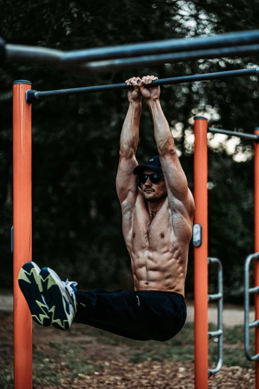 a man doing pull up bars in a park