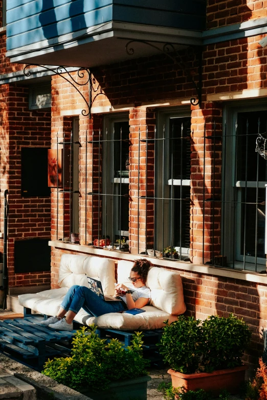 a woman sitting on a couch in front of a building