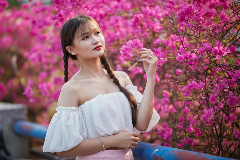 asian woman in pink skirt holding a flower