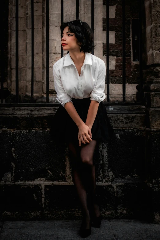 a woman wearing black tights sits on a ledge