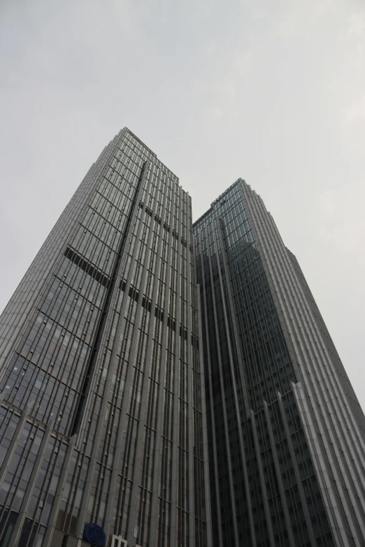 looking up at two large glass buildings