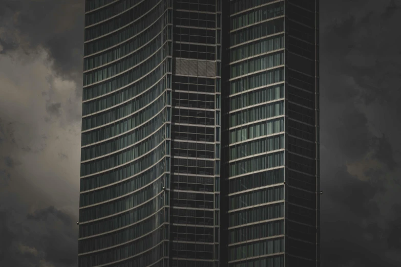 two tall buildings with lots of windows under a dark sky