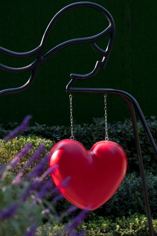 a heart shaped balloon hanging from a sculpture