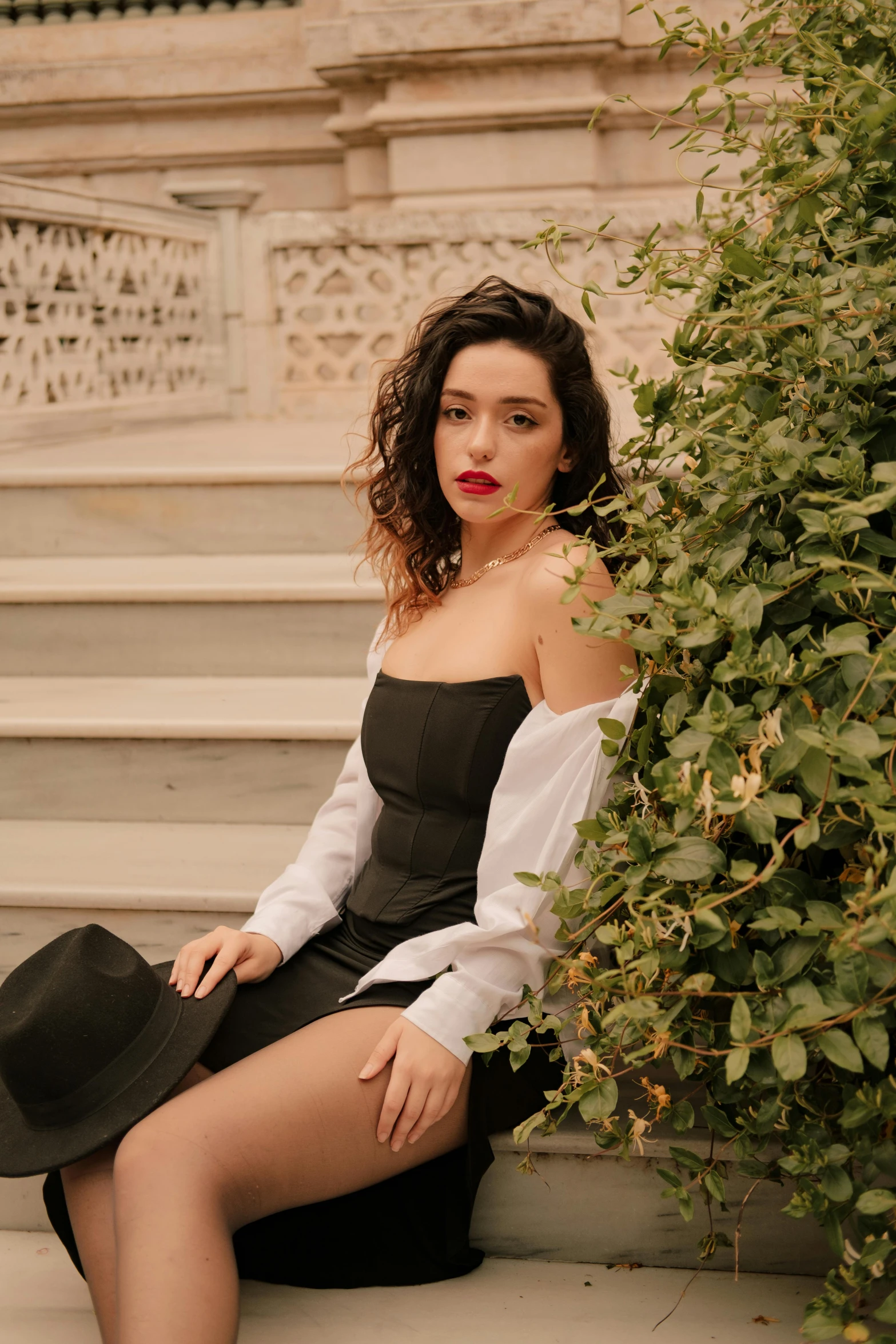 a beautiful woman in a white blouse sitting on the steps