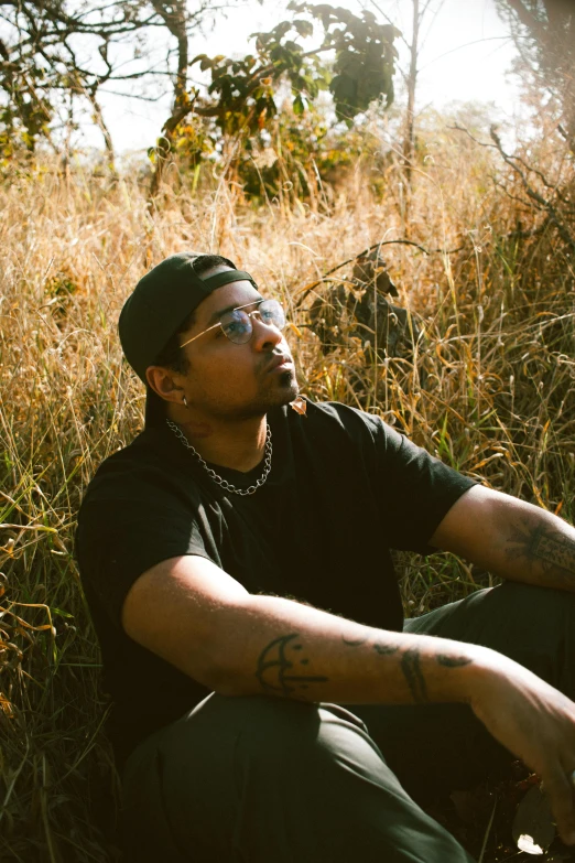 a man sitting on a field staring in the distance