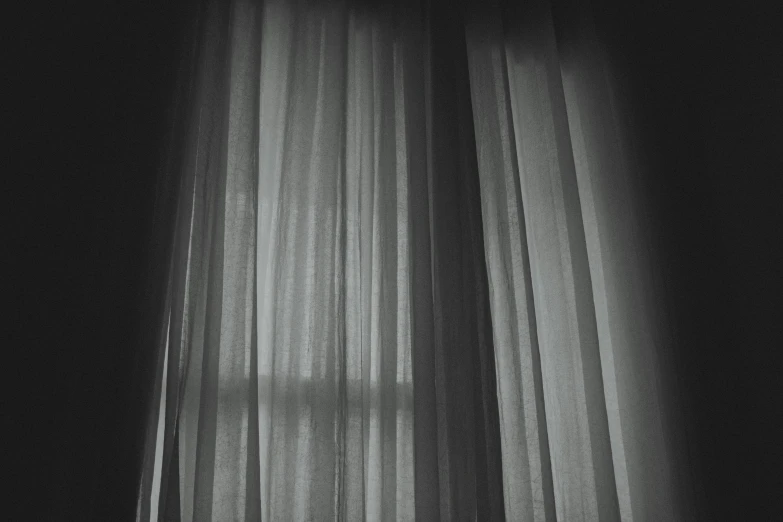 the curtains are lined up on a window sill