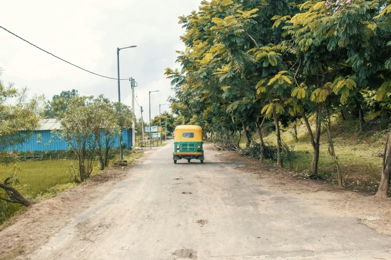 a truck driving down a dirt road near a forest