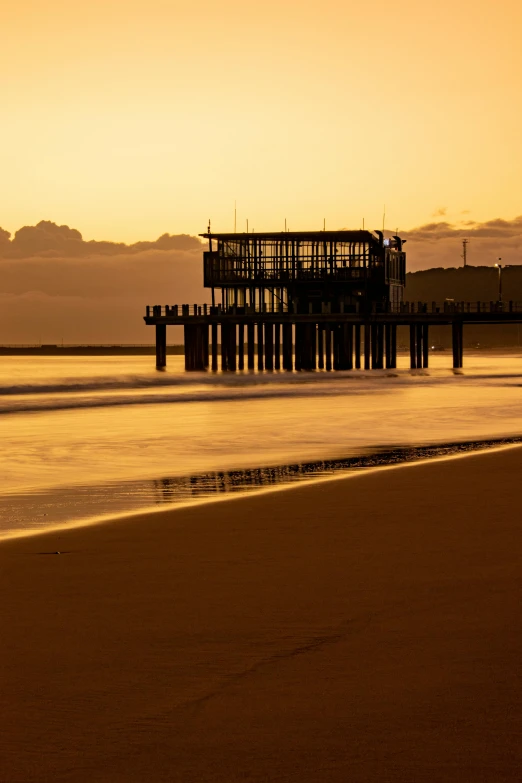 a pier near the water at sunset in the ocean