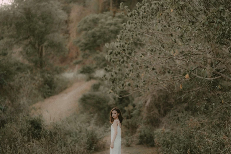 a woman standing on a dirt road