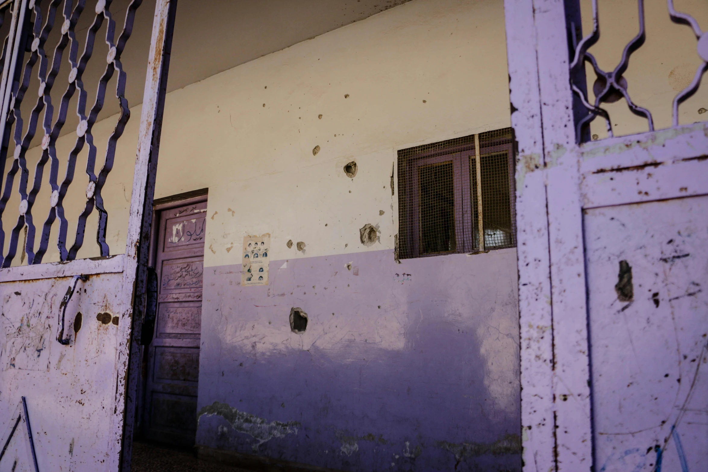 door is partially open in front of a dilapidated house