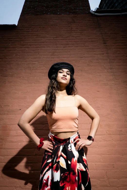 young woman with top and skirt in front of brick wall