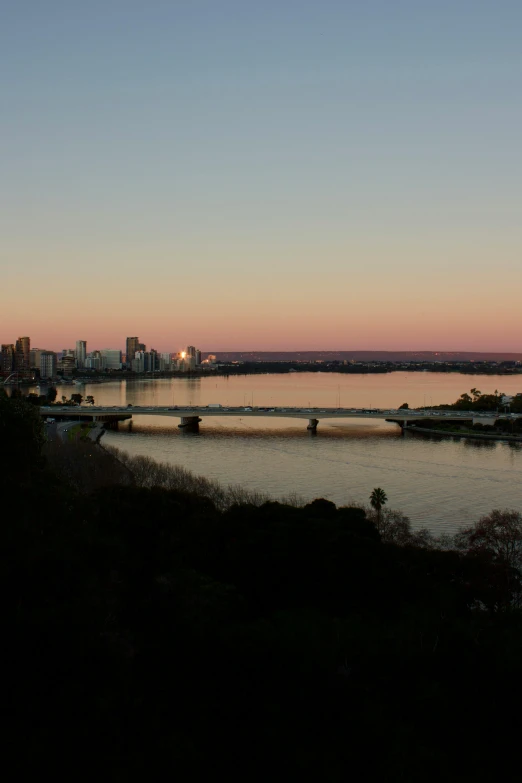 a view of a city and a large body of water at sunset