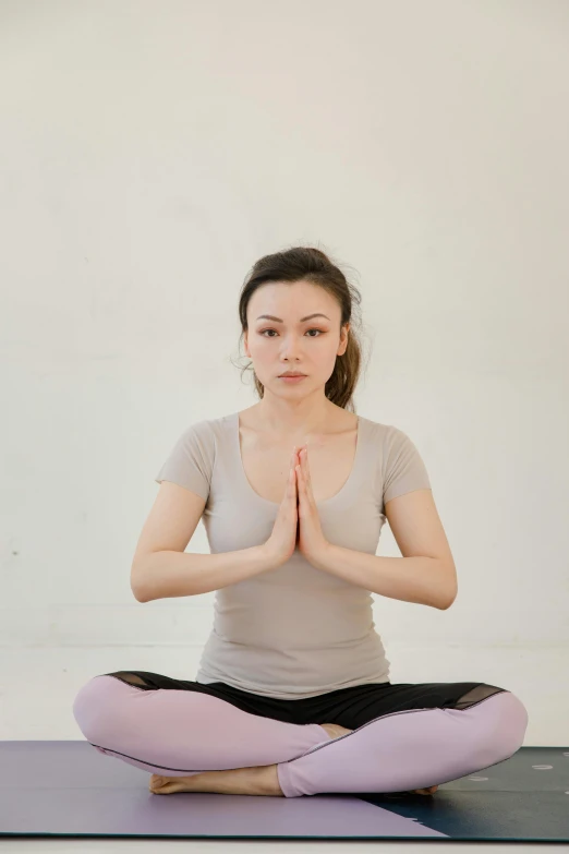 a young woman is doing yoga poses with her hands together