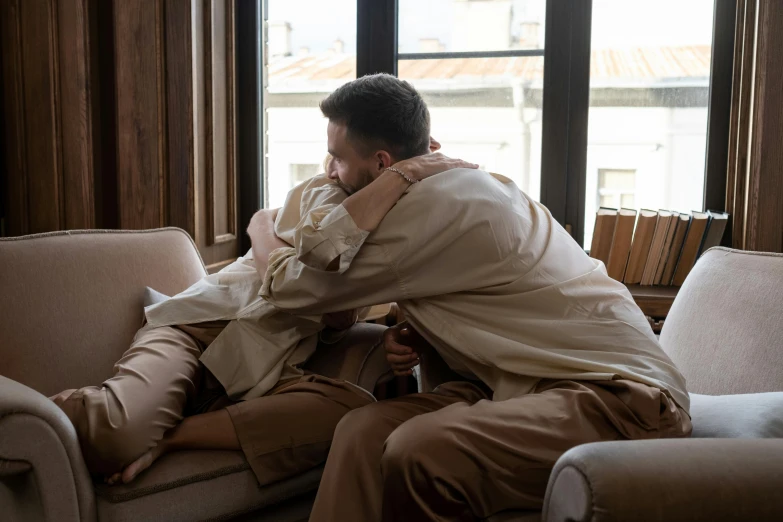 a man is holding his back in an apartment by the window