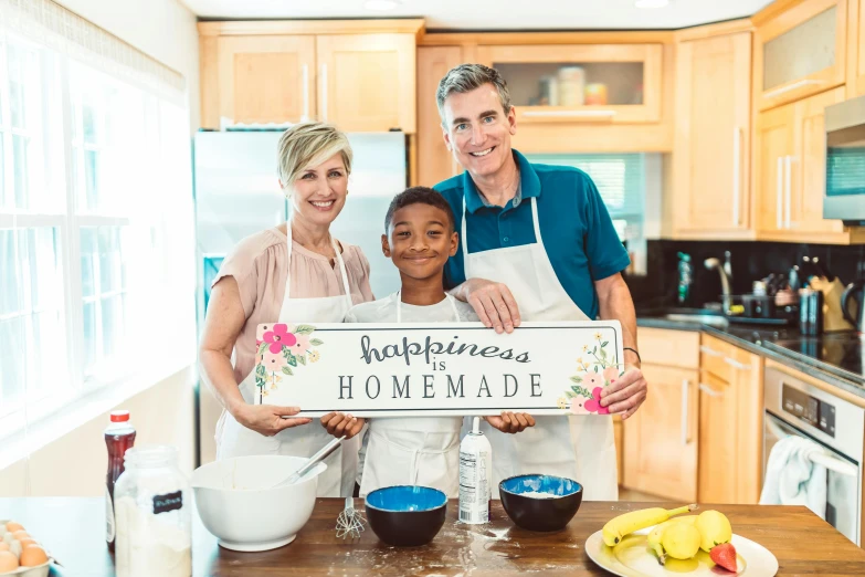 a family in the kitchen posing for the camera