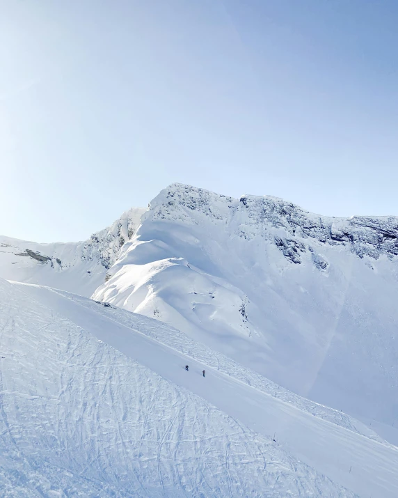 skiers going down a mountain with high snow