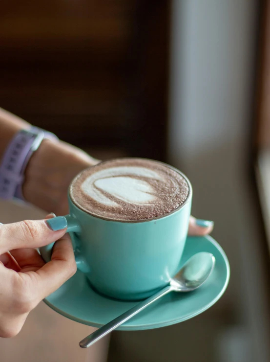 a cup of  chocolate in someones hand