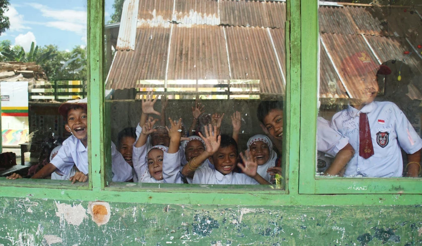 a group of children in uniform looking out a window